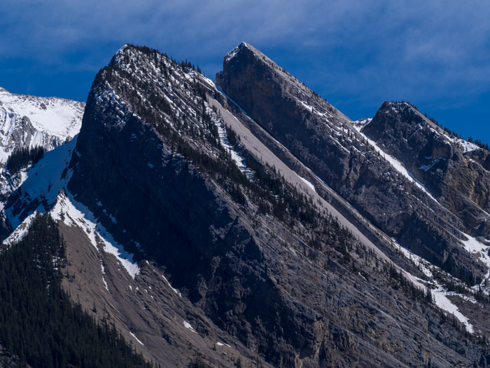 Rugged mountain made of tilted crust strata showing exposed crust layers.